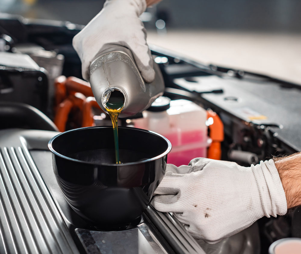 a person is pouring the oil in the car